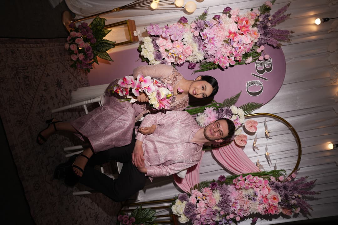 Okan and Bintan at their engagement with floral backdrop